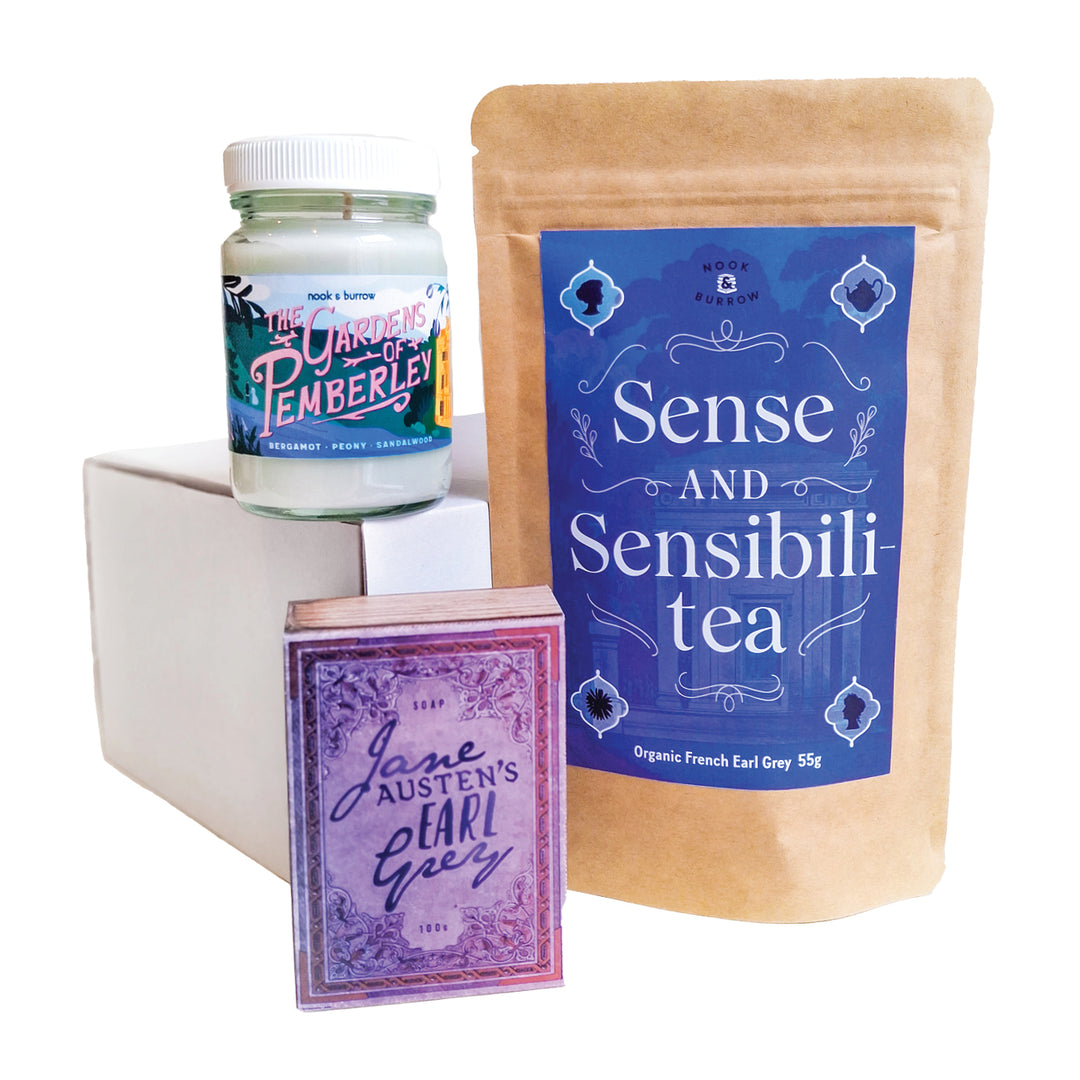Jane Austen-themed gift set featuring “Sense and Sensibili-tea” organic French Earl Grey tea, “The Gardens of Pemberley” candle, and “Jane Austen’s Earl Grey” soap in elegant purple and blue packaging.