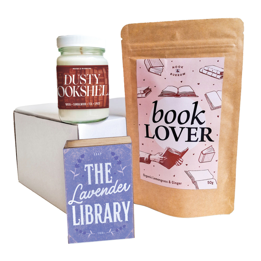 Bookish bundle with “Book Lover” lemongrass and ginger tea, “Dusty Bookshelf” candle, and “The Lavender Library” soap in pastel tones.