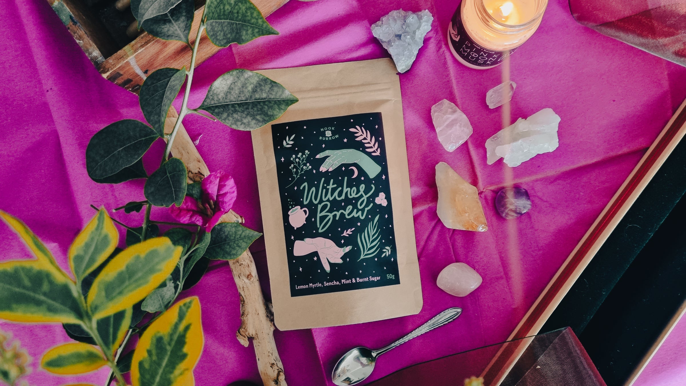 Witches Brew Sencha Green Tea flatlay with crystals and plants around it